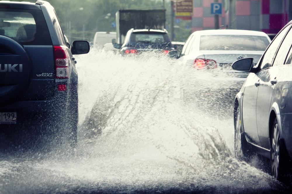 A safe driver's course can help you avoid hydroplaning. Car splashing water on other vehicles during winter rain.