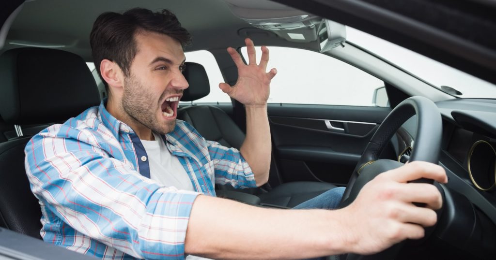 Man experiencing road rage in car.