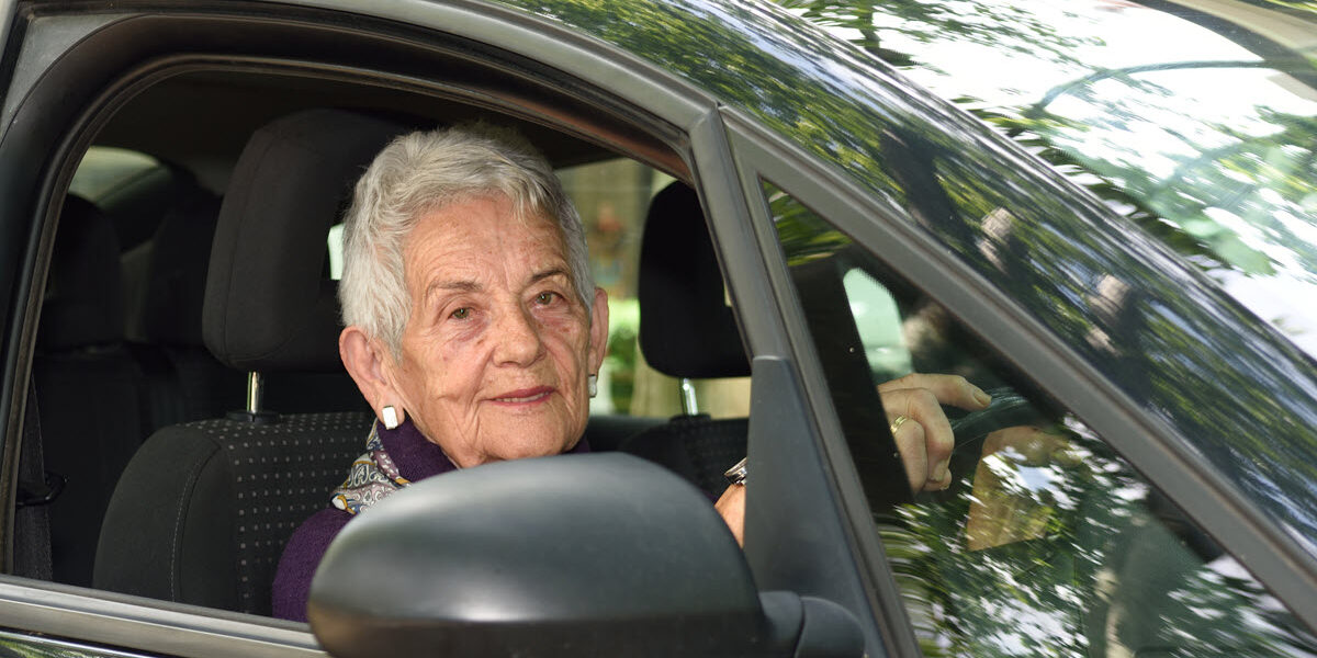 Senior woman taking driving assessment for the elderly after lessons.
